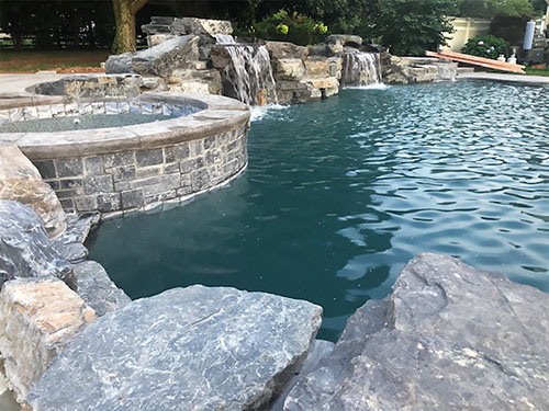 qraised spa with boulders poseidons custom pool